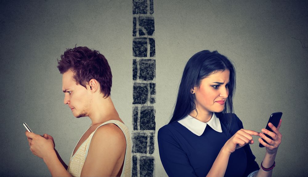 Angry couple looking at their phones